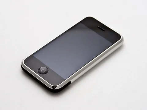 The first iPhone lying at an angle on a white surface